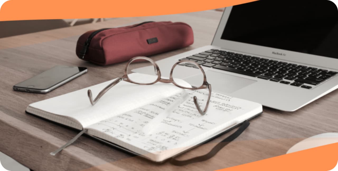 glasses on a notebook in front of a laptop