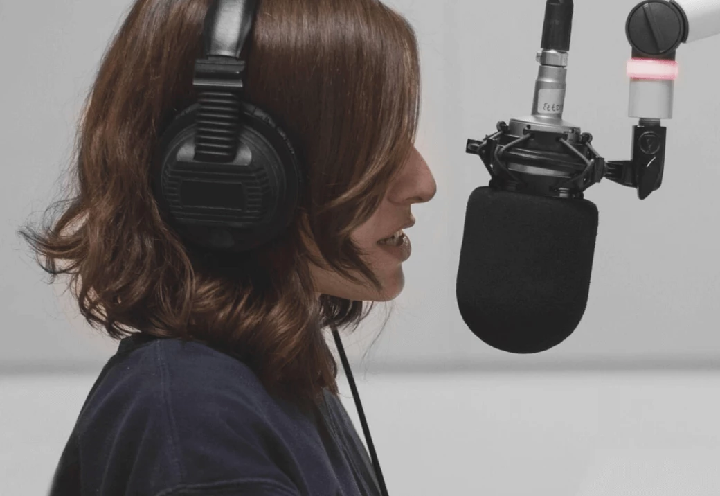 woman with headphones speaking into a microphone