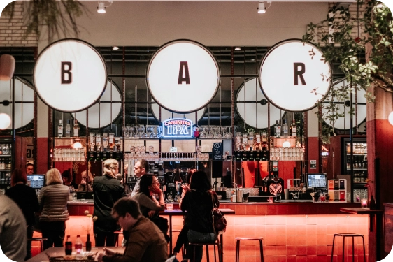 A bar at night time with people getting drinks