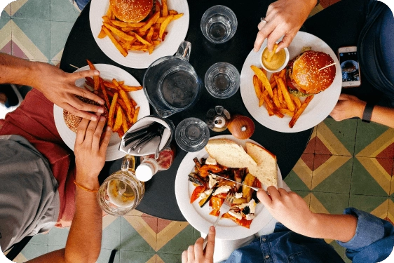 Four people around a table with plates of food