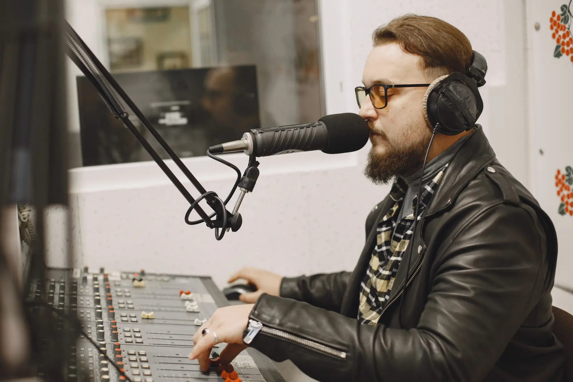 man in radio studio with microphone and mixing desk